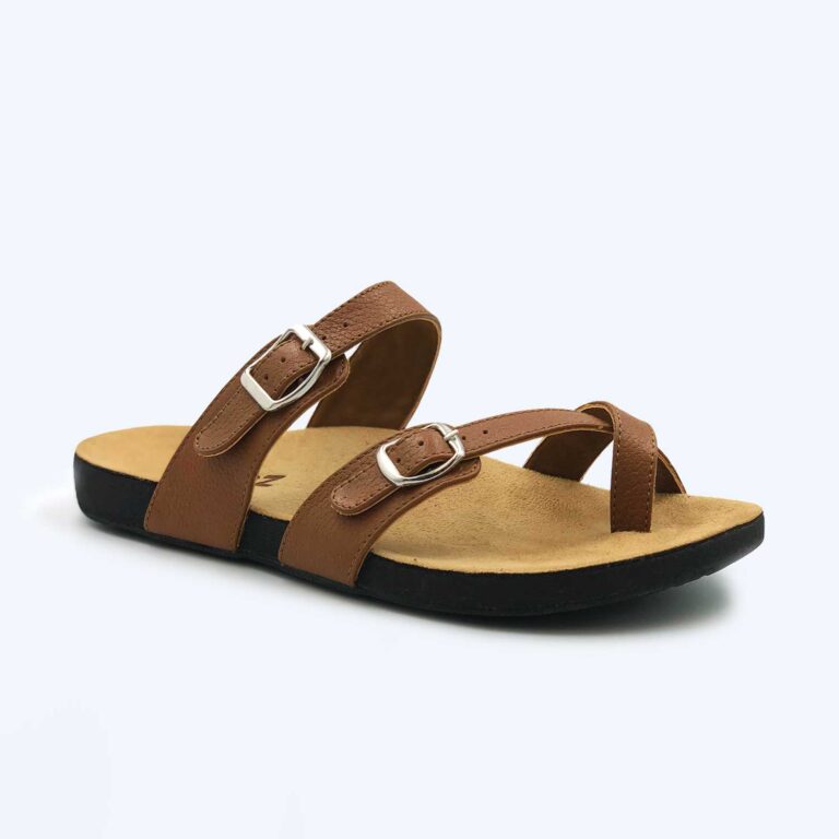 Anna – Black sandal with two adjustable buckle straps and a cross strap, featuring a flat black sole and tan footbed, displayed against a plain light background.