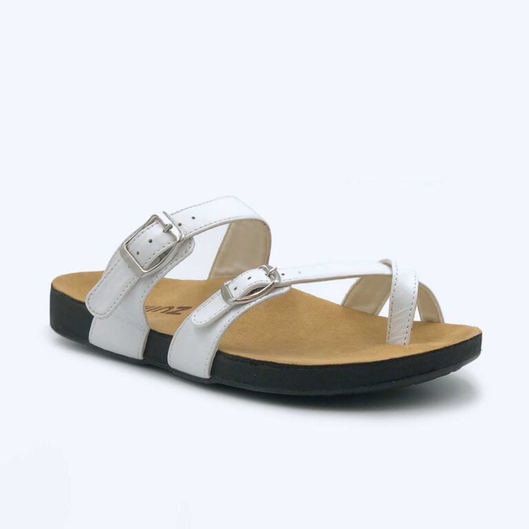 The Anna – Black sandal shown on a plain light background features a white upper with two adjustable buckle straps, a tan footbed, and a black sole.