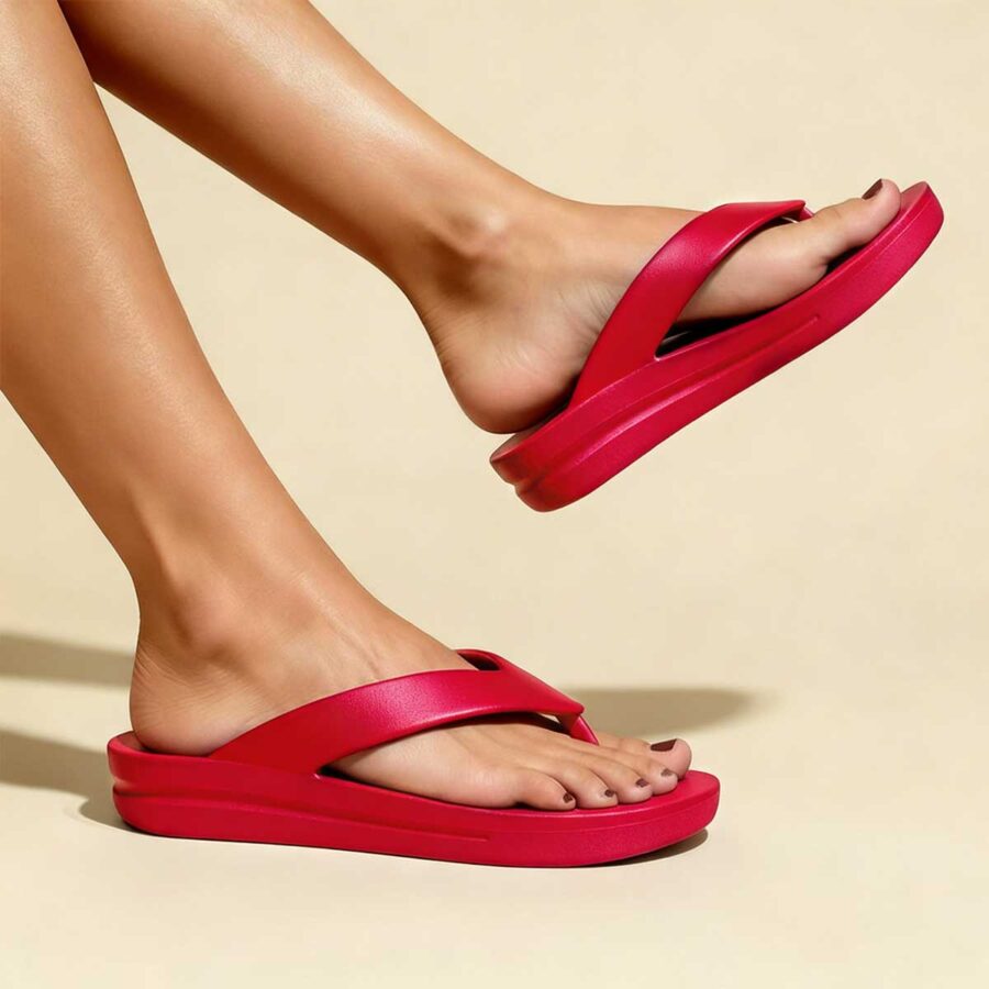 Someone wearing TIKI – Raspberry Red platform flip-flop sandals on a neutral background.